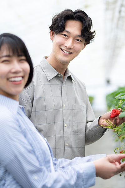 成婚して幸せそうに指輪を見せるカップルの縦長画像